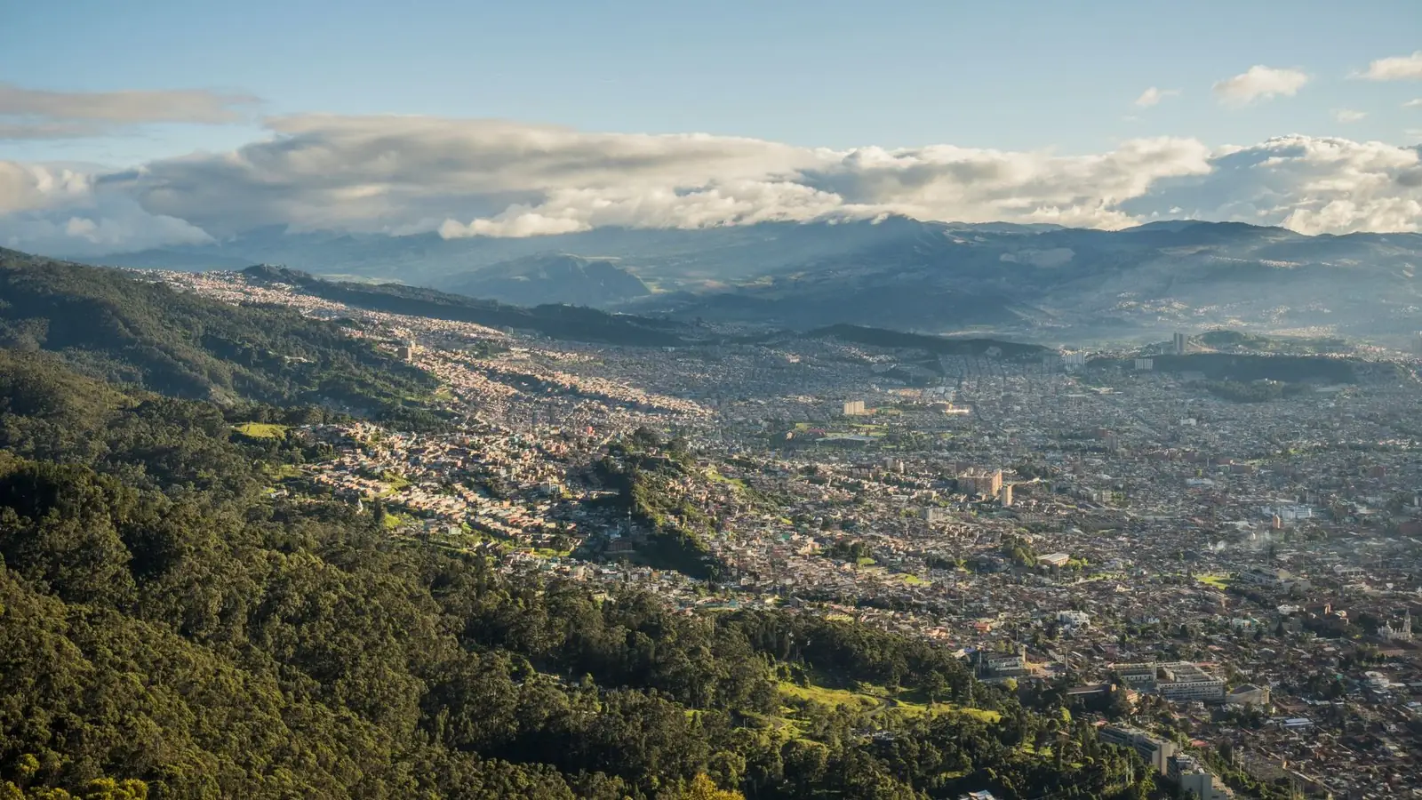 An aerial view of Bogotá spread across the valley below the Andes