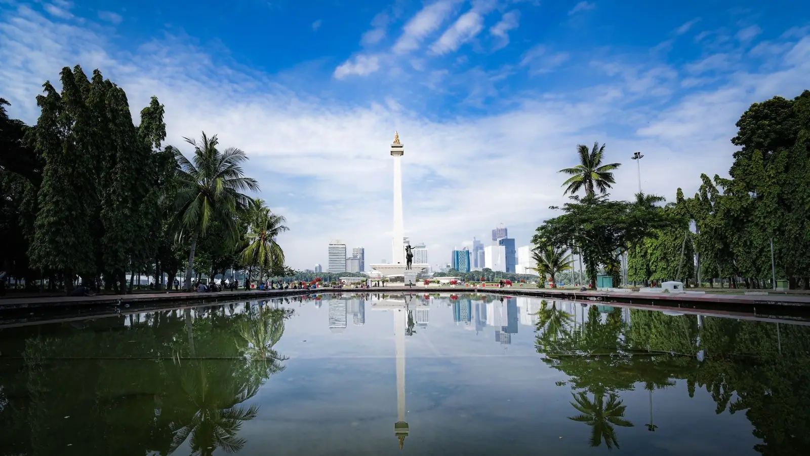 The National Monument (Monas) and Jakarta skyline reflected in a pond