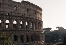 Cheap flights to Rome: Fiumicino vs Ciampino, the train question, and the ZTL that fines you by mail The Colosseum in Rome in warm daylight with umbrella pines behind