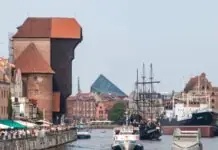 The Reality of Gdańsk: Rebuilt Facades and the Weight of History The medieval Crane and merchant houses on the Motława riverfront in Gdańsk, with tourist galleons