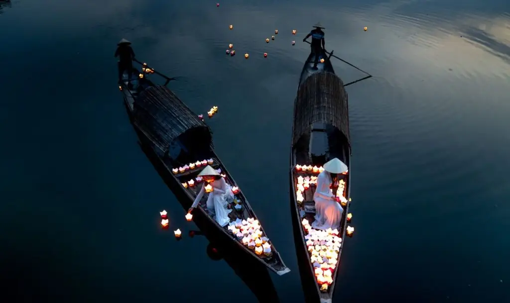 Boats filled with glowing lanterns on the river in Hoi An