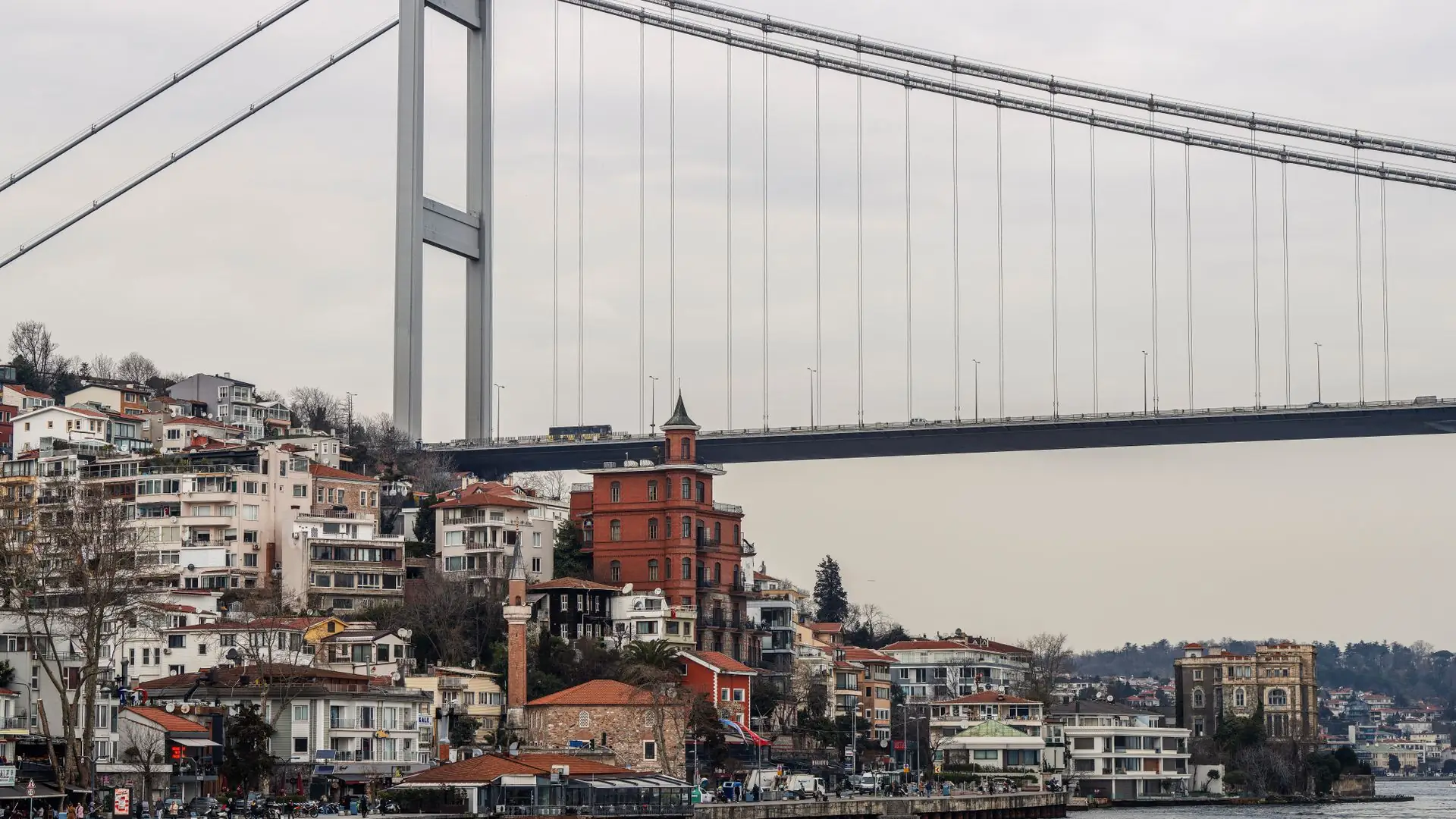 A Bosphorus suspension bridge above waterfront houses in Istanbul