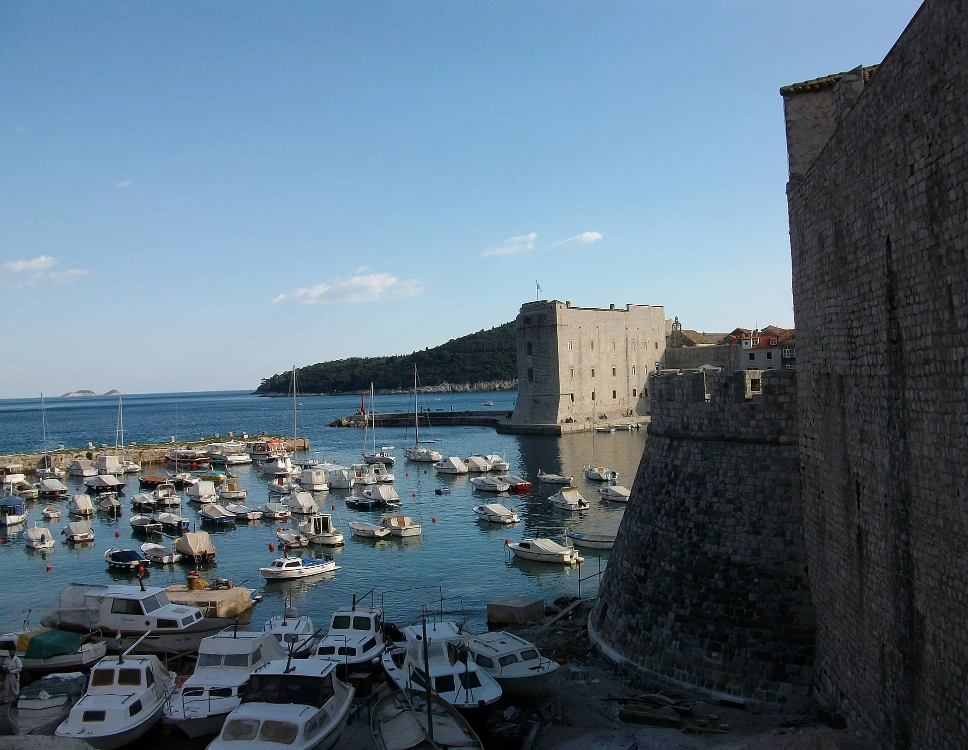 Boats in the old port of Dubrovnik beside the city walls