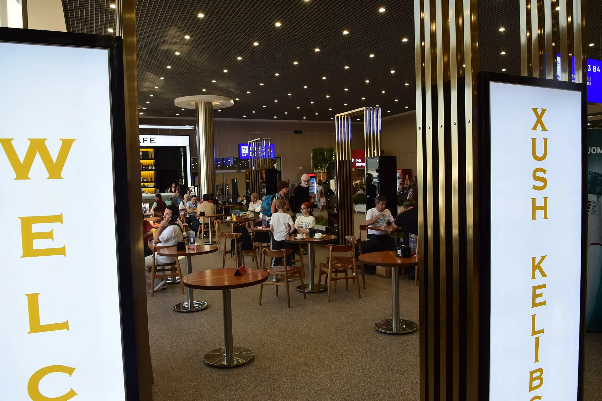 Cafe seating and welcome signs inside the international terminal at Tashkent airport