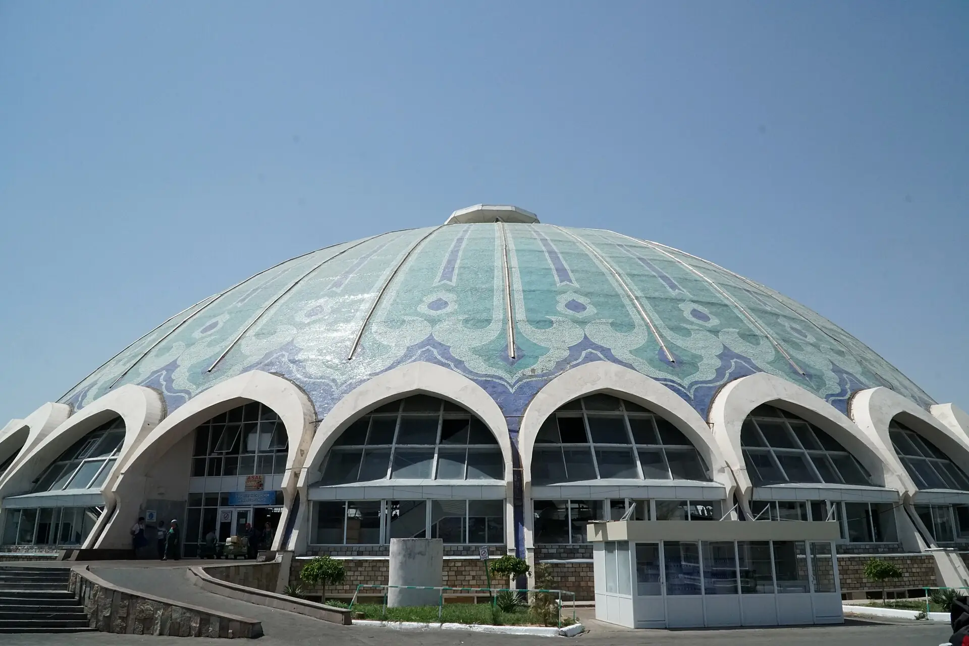 Turquoise tiled dome of Chorsu Bazaar in Tashkent with arched facade