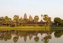 The five towers of Angkor Wat reflected in the water in late-afternoon light