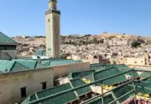The Reality of Fez: the city that never let the car in — what a medieval city sounds like when nothing has an engine Green-tiled roofs and minaret of the Kairaouine mosque above the Fez medina