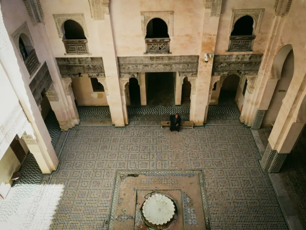 Tiled courtyard of a historic medersa in Fez with a central fountain