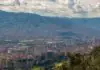 Cheap flights to Medellín: the airport over the mountain, the one in the middle of town, and the morning fog that reshuffles both Aerial view of Medellín in a mountain valley