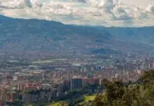 Cheap flights to Medellín: the airport over the mountain, the one in the middle of town, and the morning fog that reshuffles both Aerial view of Medellín in a mountain valley