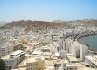 The Reality of Muscat: The Capital That Chose Not to Build Up Aerial view of Muscat coastal city against arid mountains