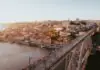 The Reality of Porto: The City That Sold Its Name The Ribeira skyline and the upper deck of the Dom Luis I bridge at golden hour in Porto